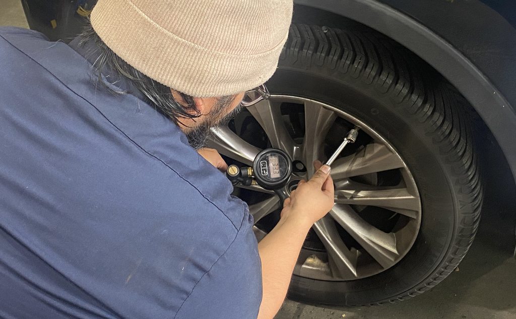 Apprentice Technician checking tire pressure on a Toyota RAV4.