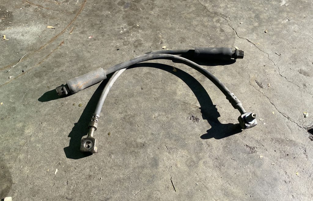 Old brake hoses on a Cadillac XTS.